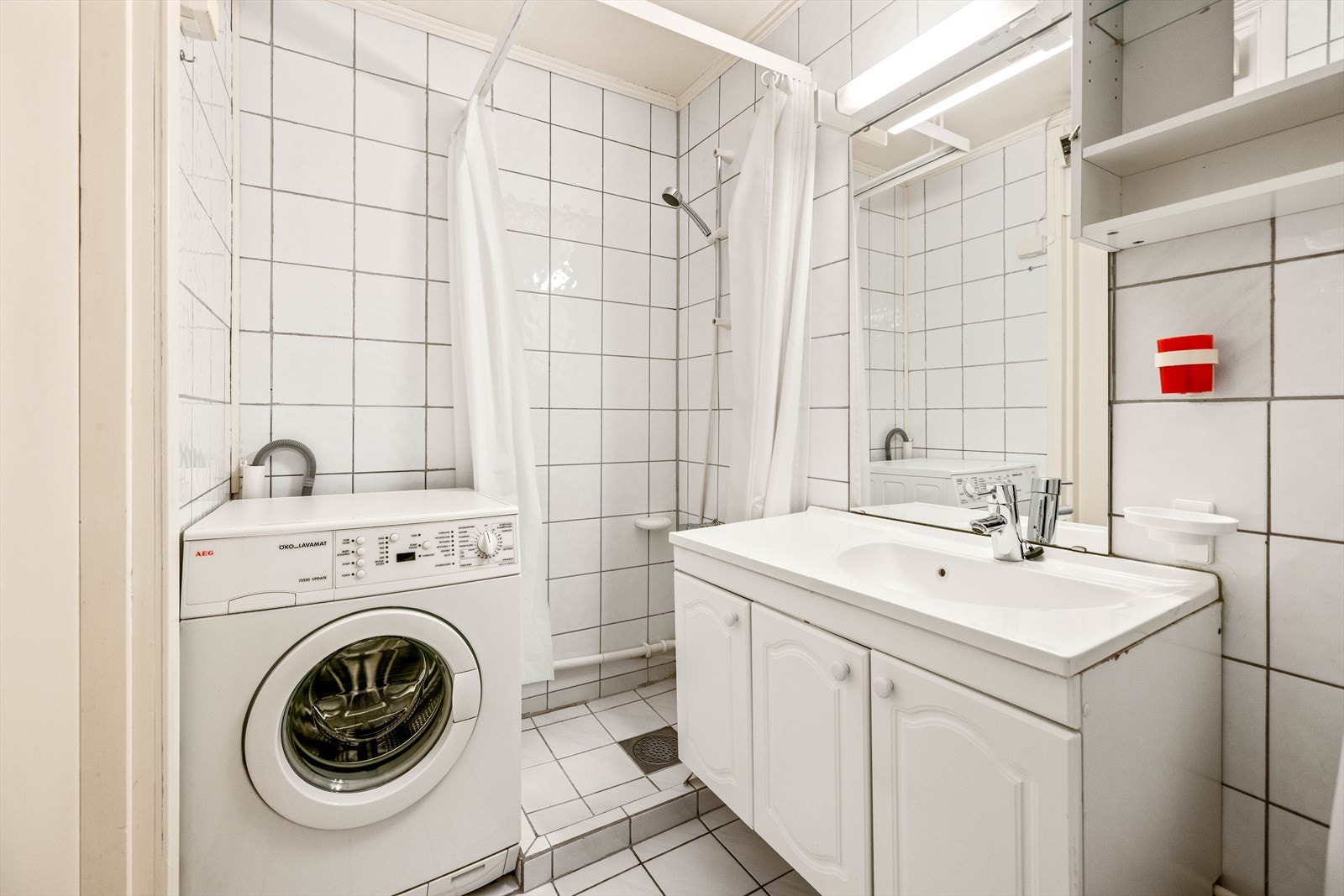 Flislagt bad med opplegg for vaskemaskin. Galleribilde