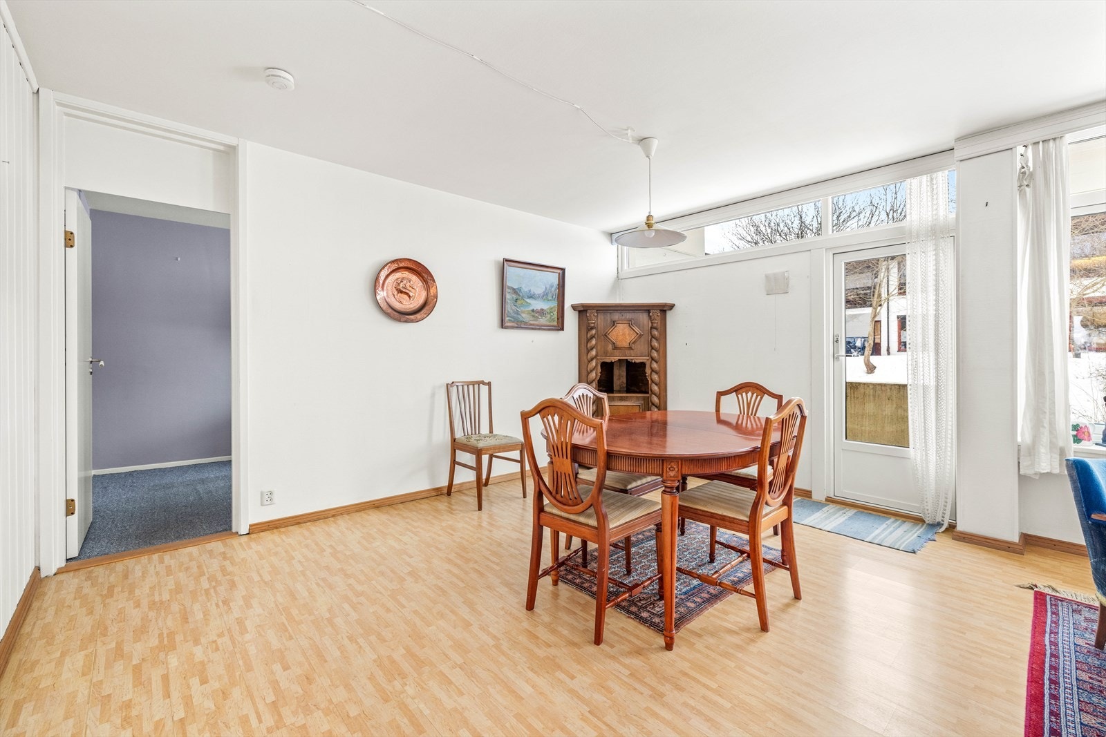 Rommet har hvitmalte overflater og laminatgulv. Det er pipeløp i hjørnet. Galleribilde