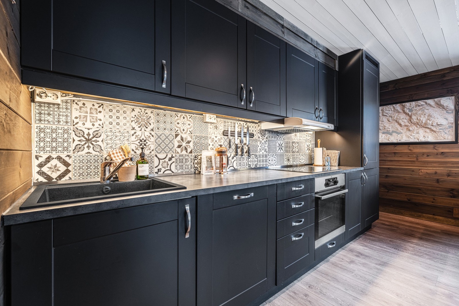 Kjøkken i mørk fargeetone - åpen løsning mot stue som gir en sosial sone Galleribilde