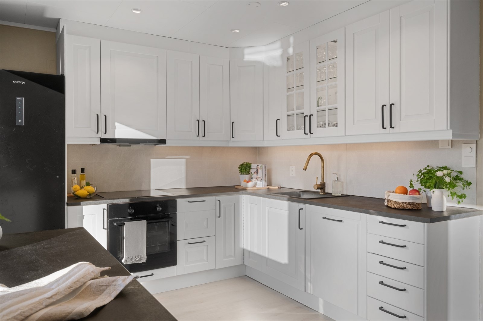 Kjøkkenet byr på en tidløs innredning med laminert benkeplate, profilerte fronter. Plater med flisemønster mellom benkeplate og overskap Galleribilde