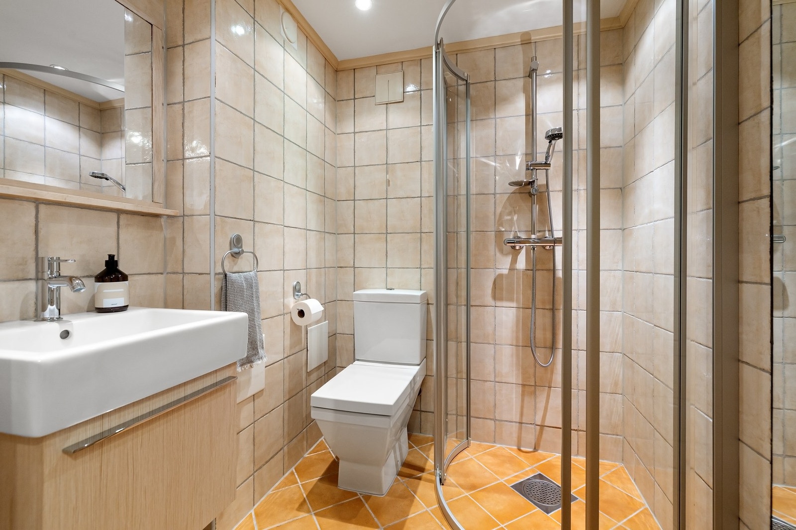 Flislagt bad/wc i u-etasjen, med varmekabler, avtrekk, speil, downlights, servant med innredning, dusjhjørne med innfellbare glassdører og toalett. Innredning fra Duravit. Galleribilde