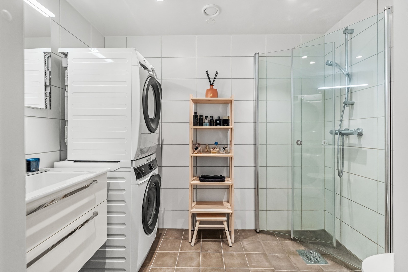 Pent flislagt bad fra byggeår. Her er det opplegg for full vaskesøyle med vaskemaskin og tørketrommel. Galleribilde