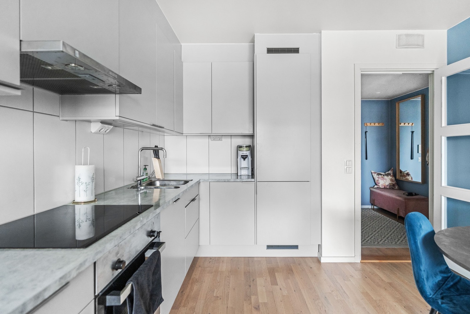 Kjøkkeninnredningen har glatte fronter og benkeplate av laminat. Det er flislagt mellom benk og overskap som gjør det lett å rengjøre. Galleribilde