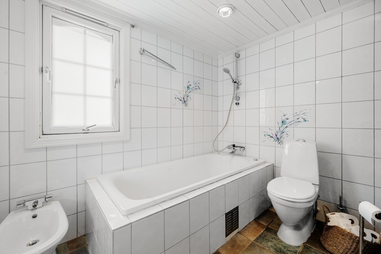 Flislagt bad med badekar, dusjkabinett, toalett og bidé. Galleribilde