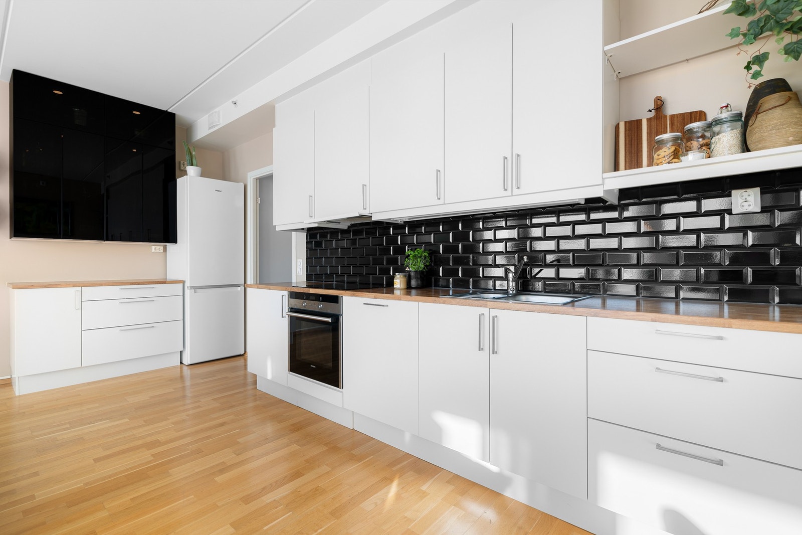 Både fint og praktisk med lekre fliser i benkeryggen og belysning under de takhøye overskapene. Kjøkkenet er utstyrt med medfølgende integrerte hvitevarer som nedfelt platetopp, avtrekksvifte, stekeovn og oppvaskmaskin. Galleribilde