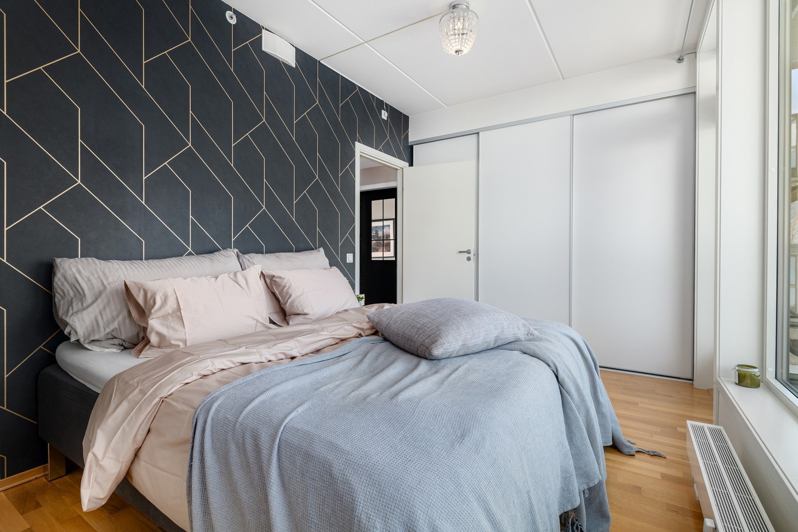 På soverommet er det god plass til stor dobbeltseng med tilhørende nattbord, samt rikelig med oppbevaringsplass i stor plassbygget skyvedørsgarderobe. Galleribilde