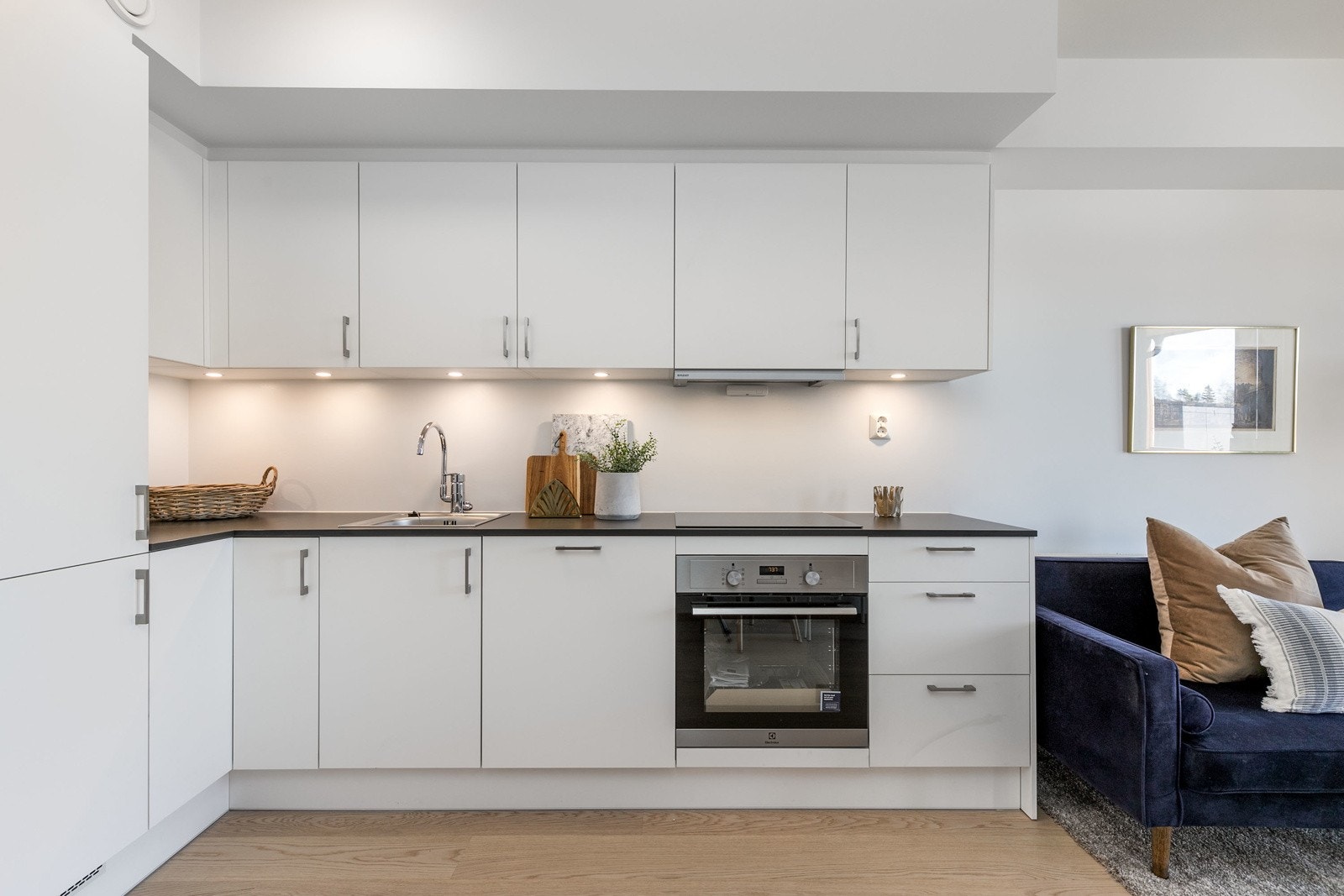 Kjøkkenet har en praktisk hjørneløsning, som gir rikelig av skap og benkeplass. Bilde fra leilighet L104. Galleribilde