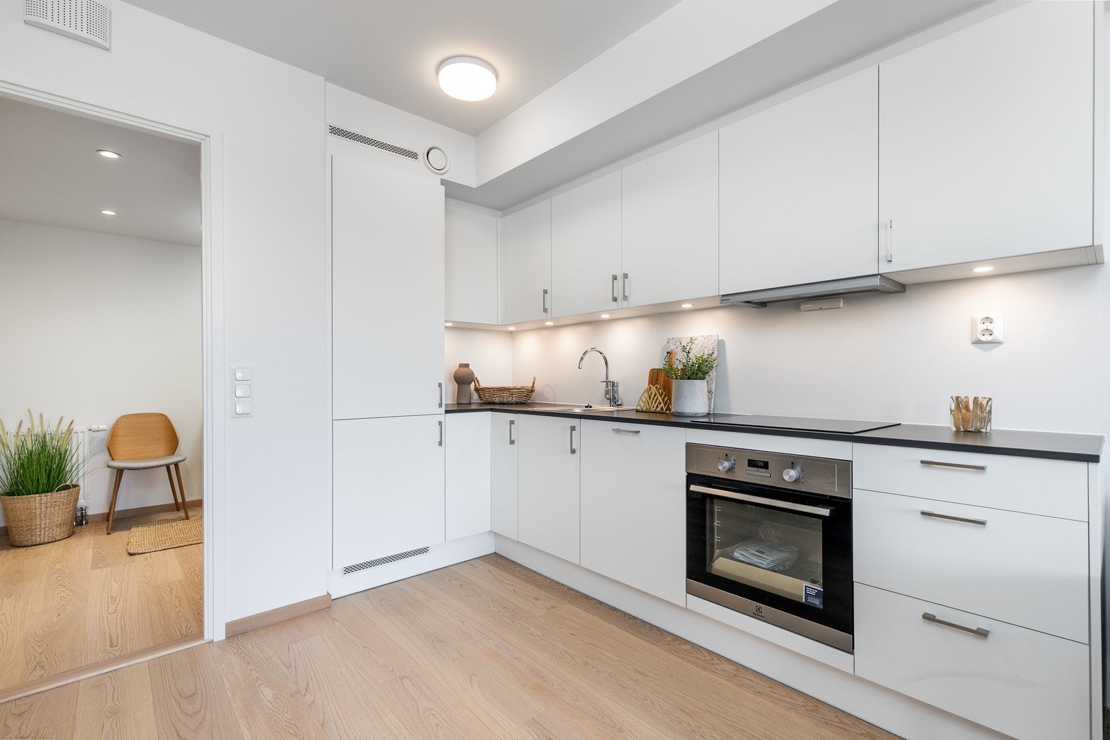 Lekkert kjøkken i åpen løsning mot stue, med integrerte hvitevarer. Bilde fra leilighet L104. Galleribilde