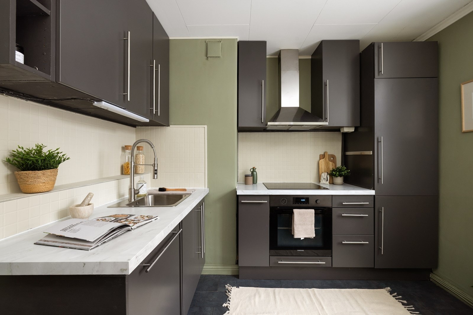 Kjøkkenet har innredning med glatte fronter. Benkeplaten er av laminat. Det er kjøl/fryseskap, oppvaskmaskin, platetopp og stekeovn. Det er kjøkkenventilator med kullfilter. Galleribilde