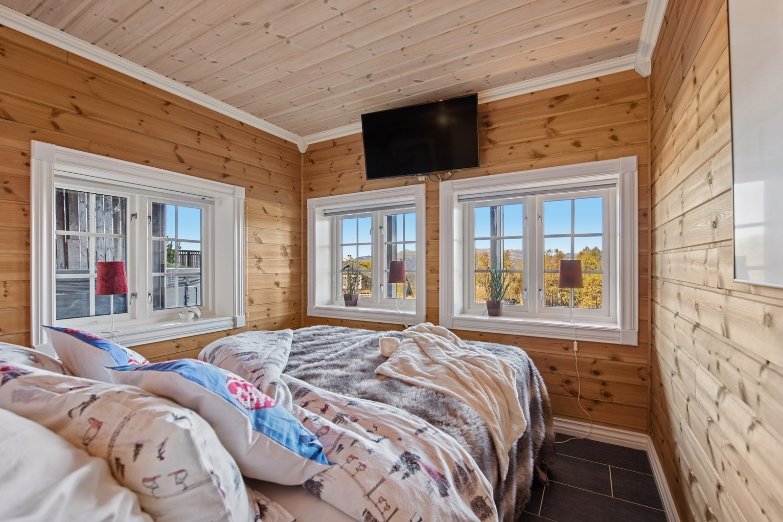 Romslig og fleksibelt rom som fungerer både som kjellerstue og gjesterom. Her er det plass til både sofakrok og gjesteseng. Flislagte gulv med varmekabler gir god komfort, og rommet har panel på vegger og i himling. Galleribilde