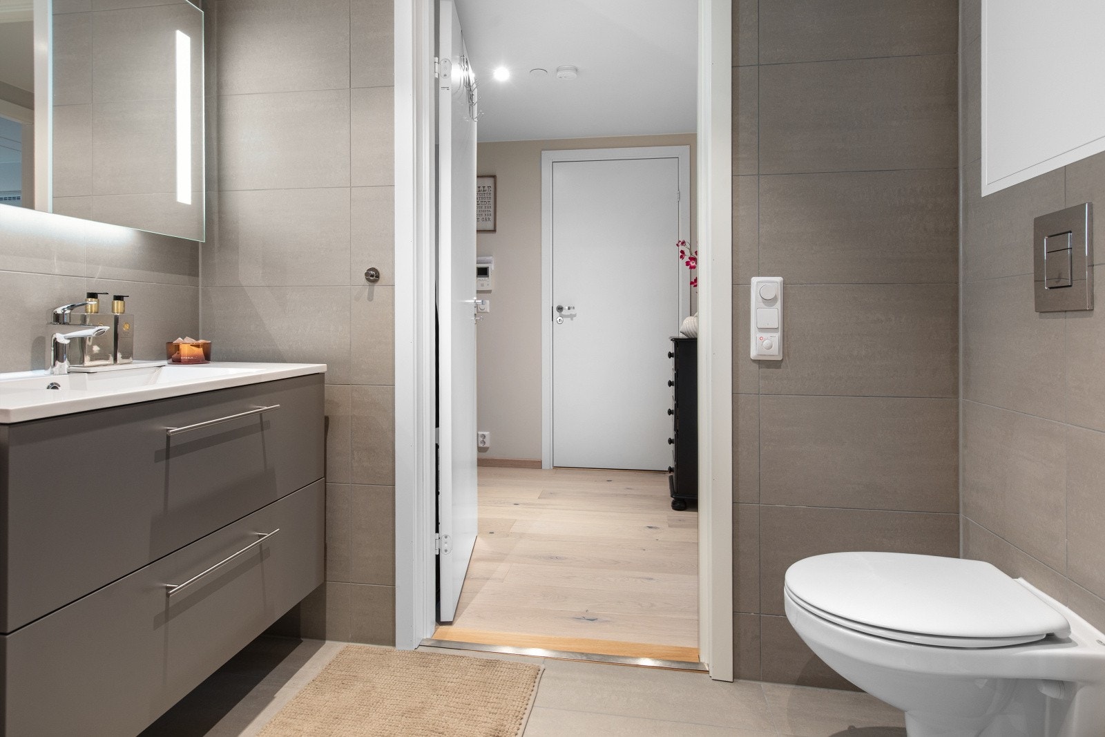 Badet er utstyrt med vegghengt toalett, dusjhjørne med svingbare glassdører, baderomsinnredning med nedfelt servant, samt speil. Galleribilde