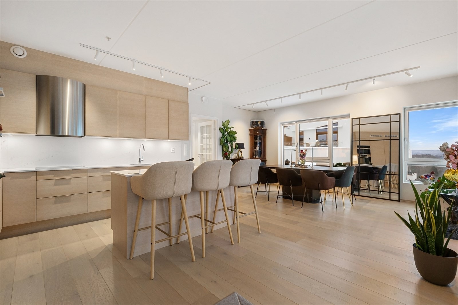 Kjøkkenet er påkostet og utformet med innredning langs to vegger og kjøkkenøy med plass til barstoler. Foto: Zovenfra Galleribilde