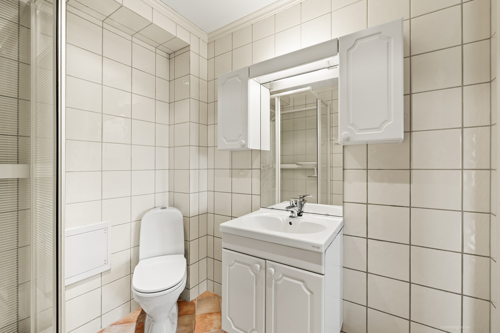 Pent flislagt bad i 1. etg. med varmekabler i gulv, klosett, baderomsinnredning med servant, dusjkabinett og opplegg til vaskemaskin. Galleribilde