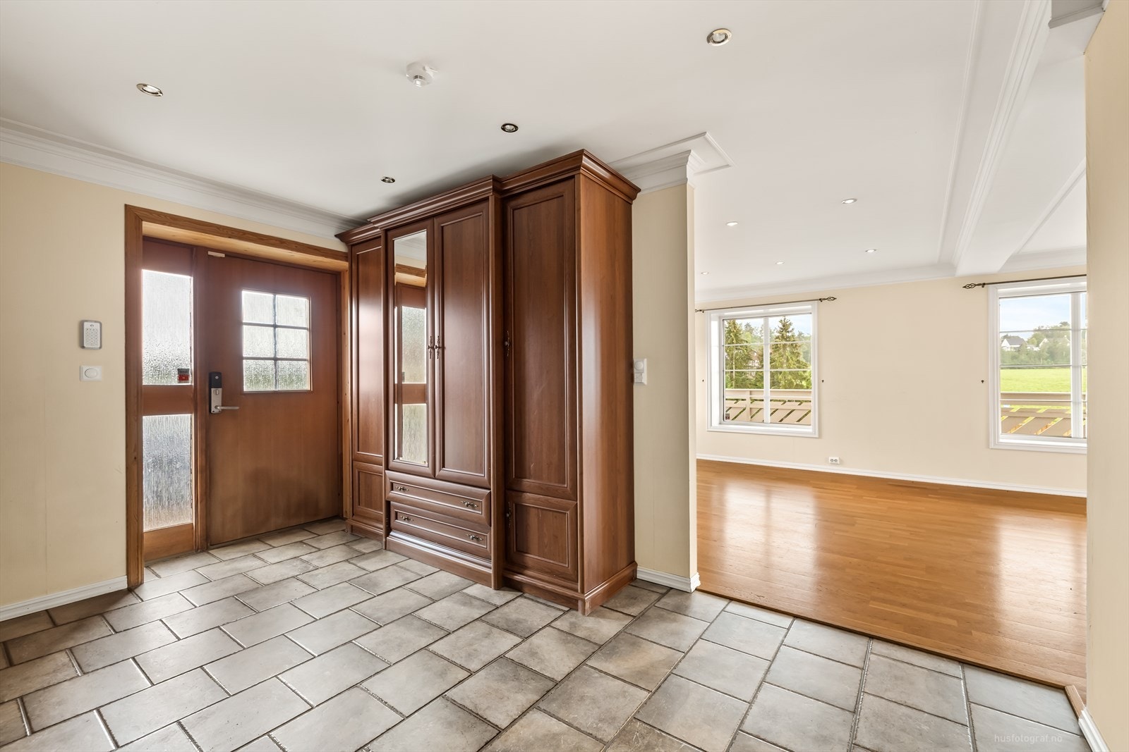 Romslig, flislagt trappehall med garderobeskap. Galleribilde