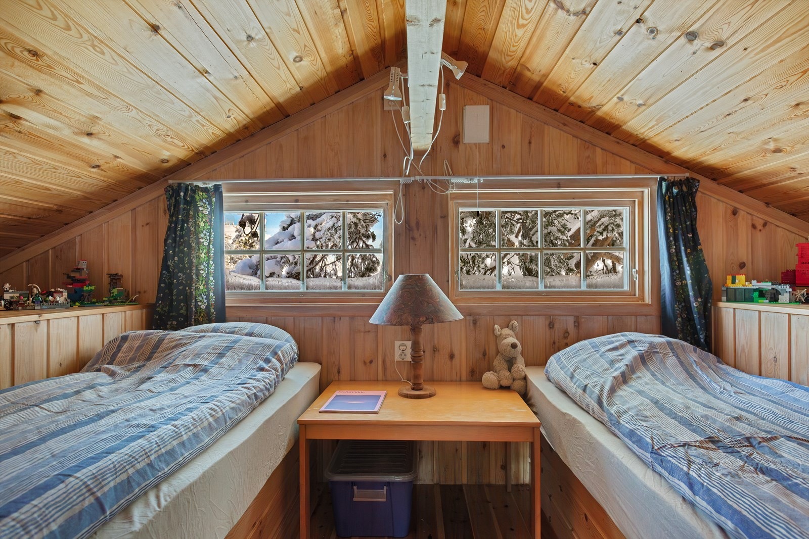 Det er også god lagringsplass på hyttas koselige hems. Selger har benyttet denne til ekstra soveplasser, men grunnet lav takhøyde er den ikke godkjent for varig opphold/soverom. Hemsen vil garantert kunne være populær som en loftstue for familiens yngste. Galleribilde