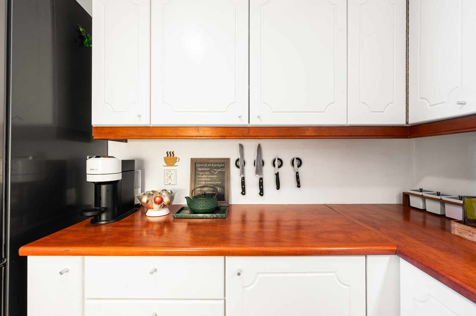 Innredningen har profilerte fronter og en benkeplate i laminat med en nedfelt kum i rustfritt stål Galleribilde