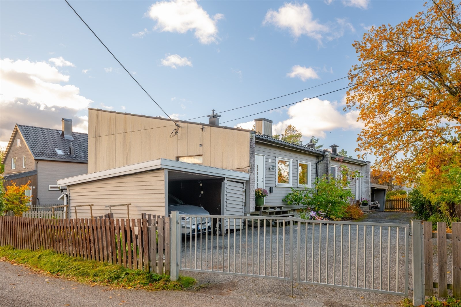 Solfylt fasade med carport og romslig innkjørsel - et praktisk og innbydende førsteinntrykk Galleribilde