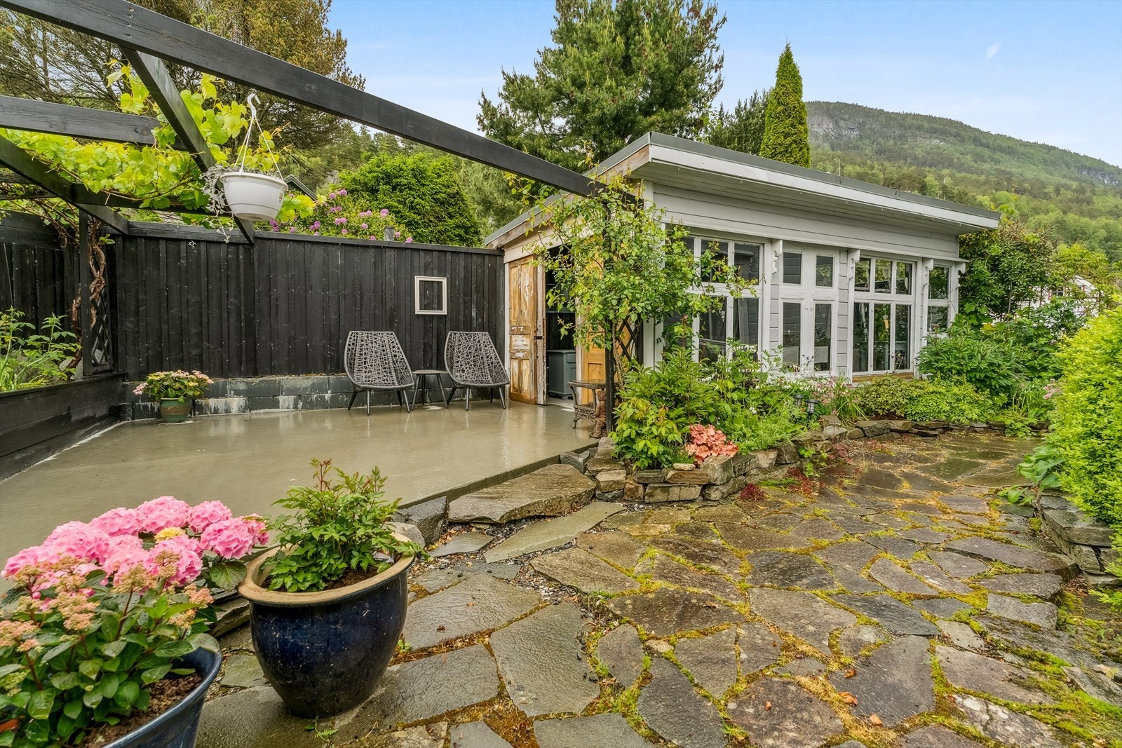 Hagen er tilnærma fullt opparbeidd med terrassar, hellelagte og singla områder, anneks og beplantning, som saman skapar eit lunt og triveleg utemiljø. Galleribilde