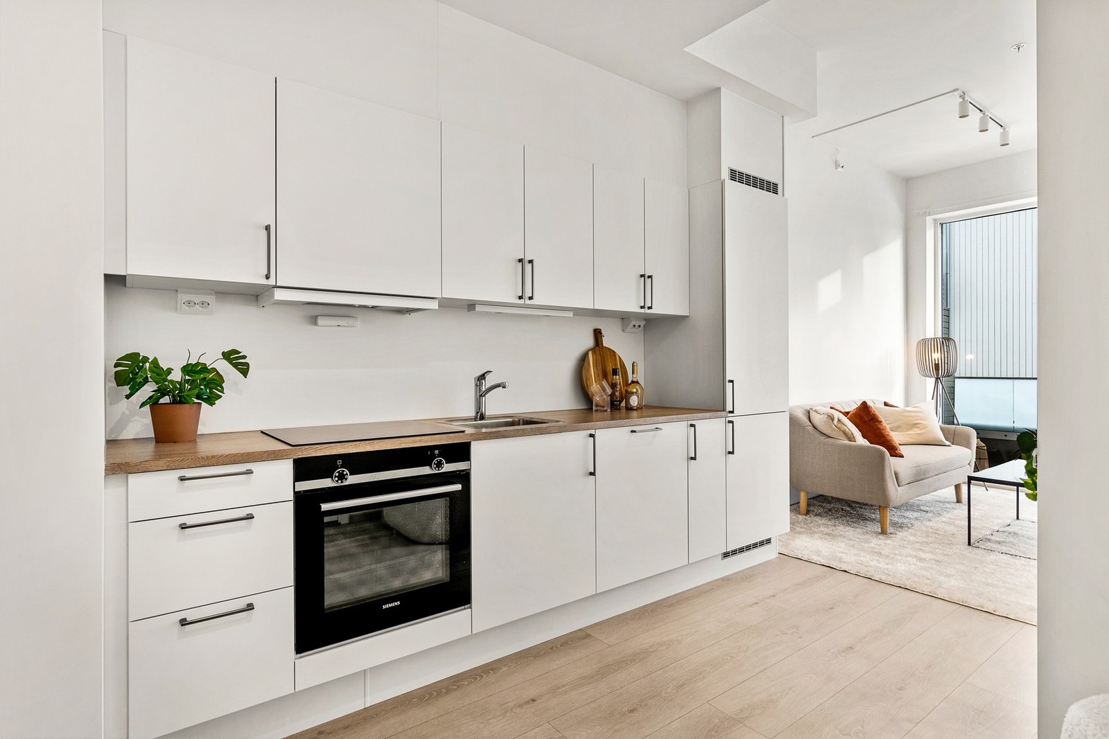 Lyst og pent kjøkken med integrerte hvitevarer. Galleribilde