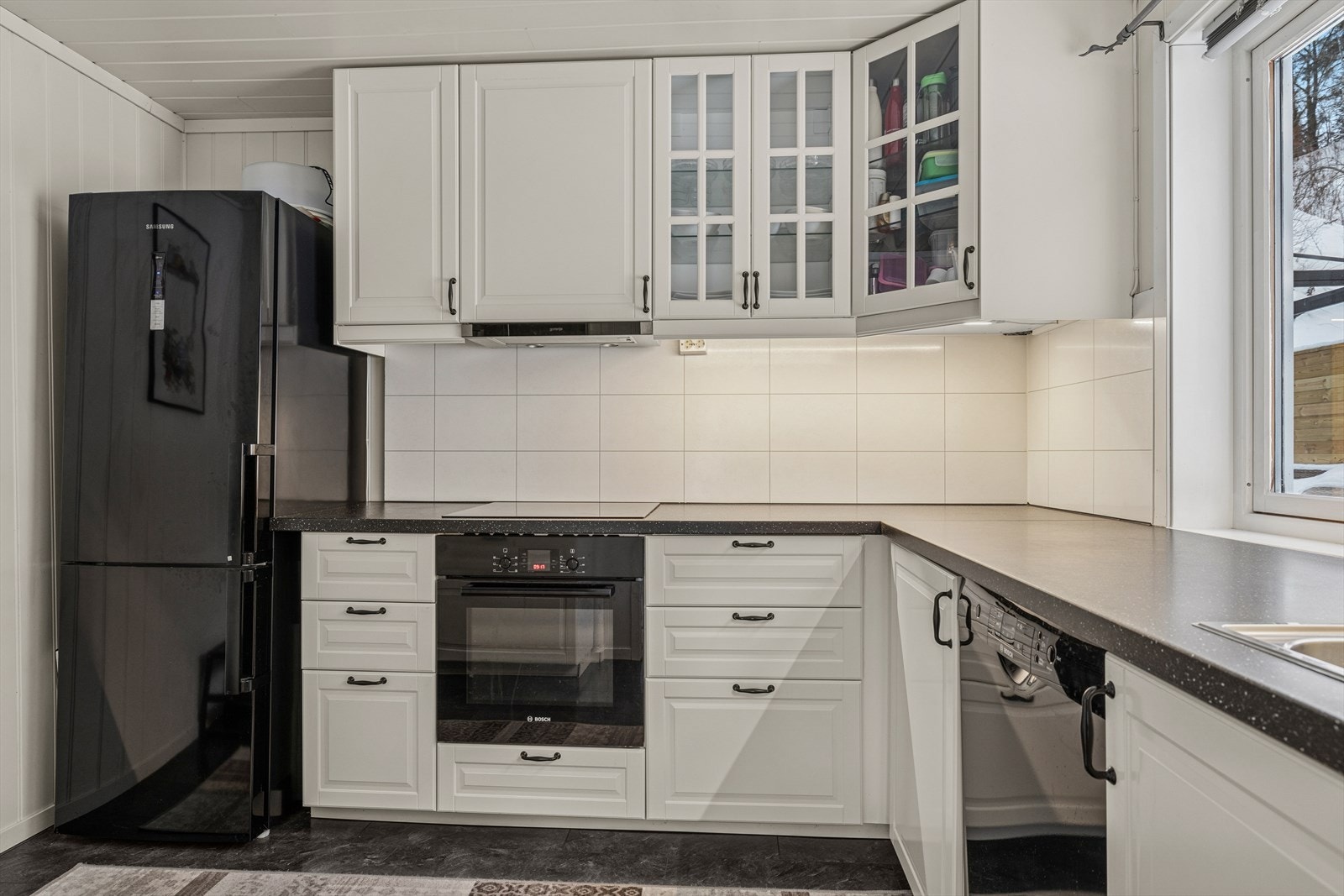 Kjøkken med mye benkplass og profilerte hvite fronter Galleribilde