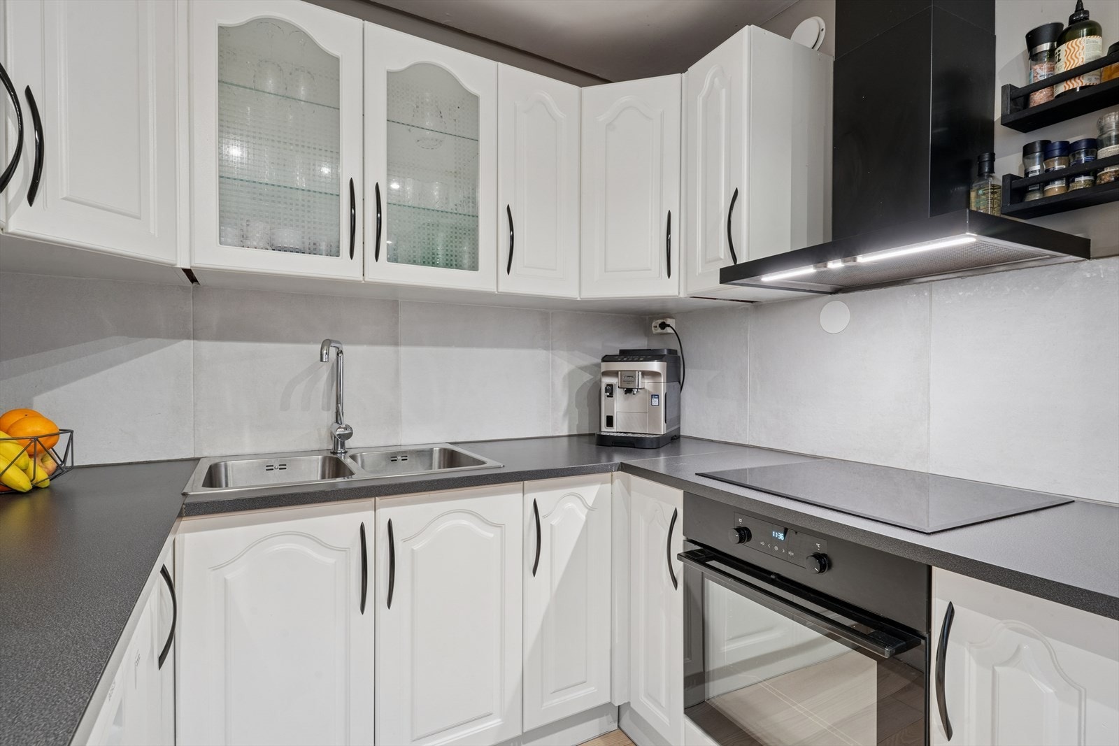 Ellers består innredningen av profilerte skapfronter med noe glassfelt i overskap, og integrerte hvitevarer som platetopp og stekeovn Galleribilde