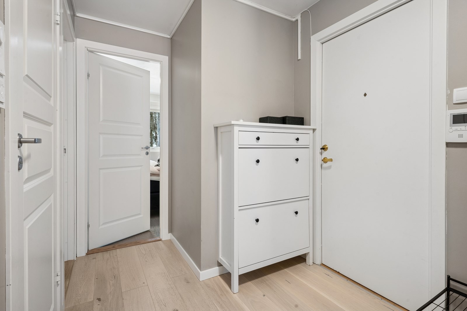 Fra byggets felles trapperom kommer man inn i en innbydende og lys entré som gir et godt førsteinntrykk av leiligheten Galleribilde