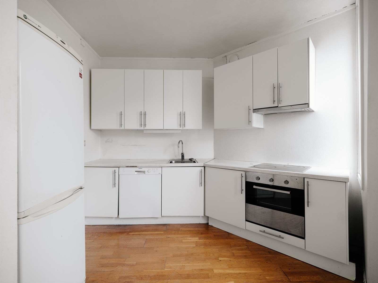 Lyst kjøkken innredet med slette overflater. Galleribilde