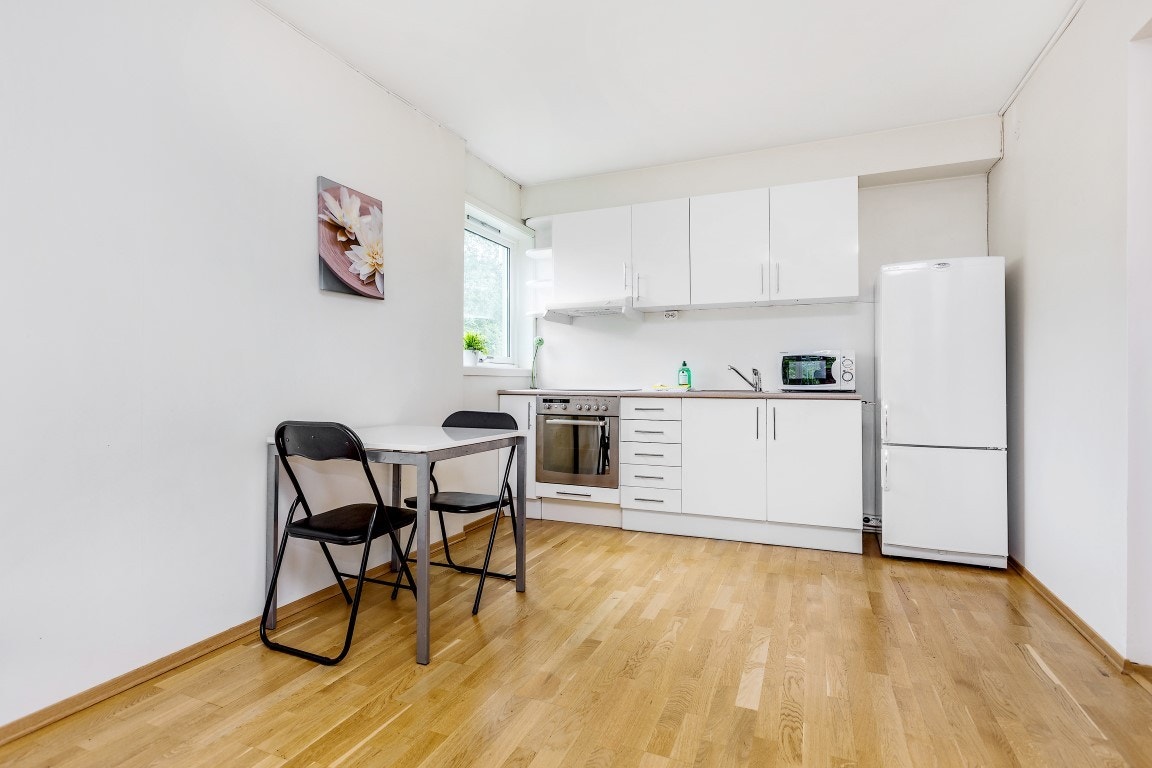 Kjøkken med hvitevarer som koketopp, stekeovn, oppvaskmaskin og kjøleskap Galleribilde