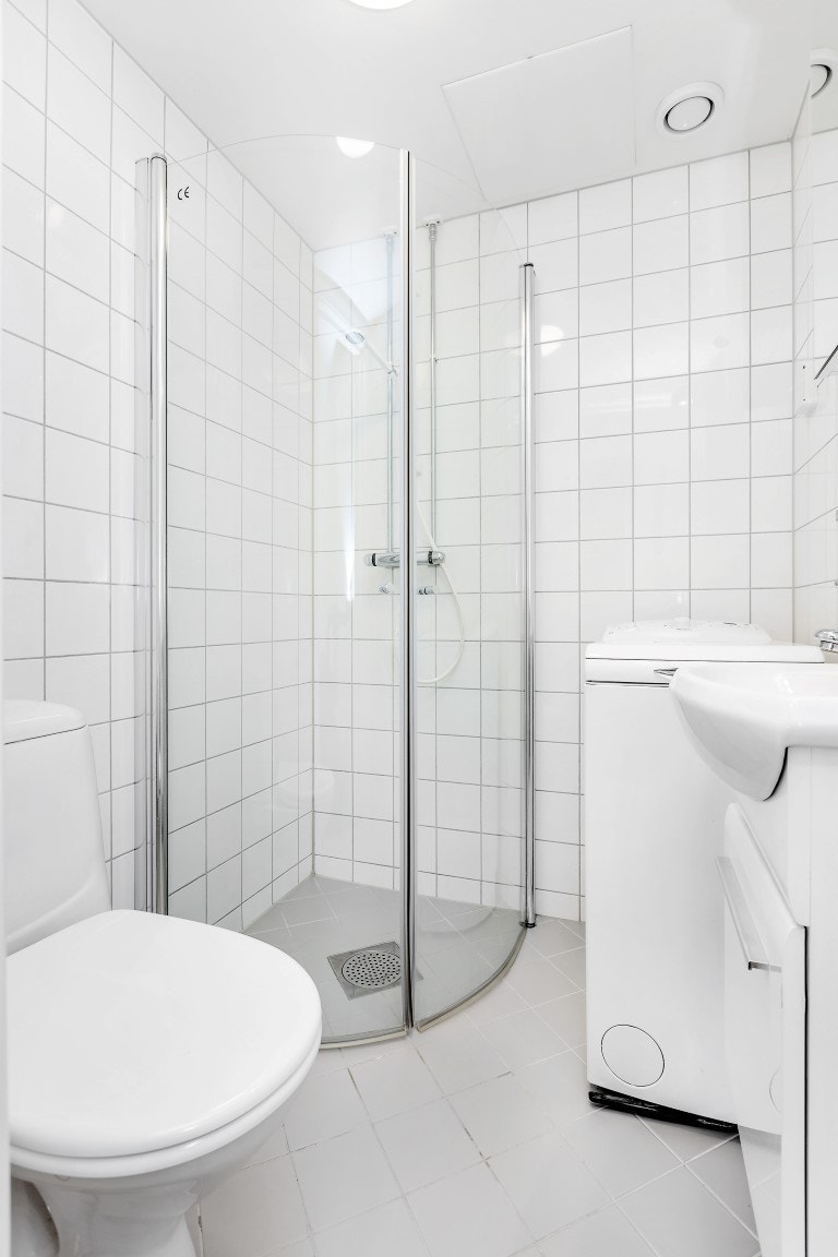 Pent flislagt bad med dusj, wc og servant. Vaskemaskin medfølger. Galleribilde