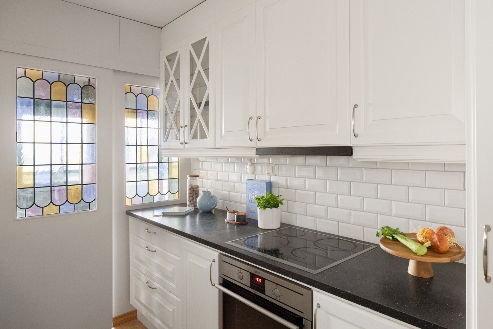 Veggen mellom benk og overskap er flislagt, og under overskapene er det benkeskapsbelysning og stikkontakter. Galleribilde