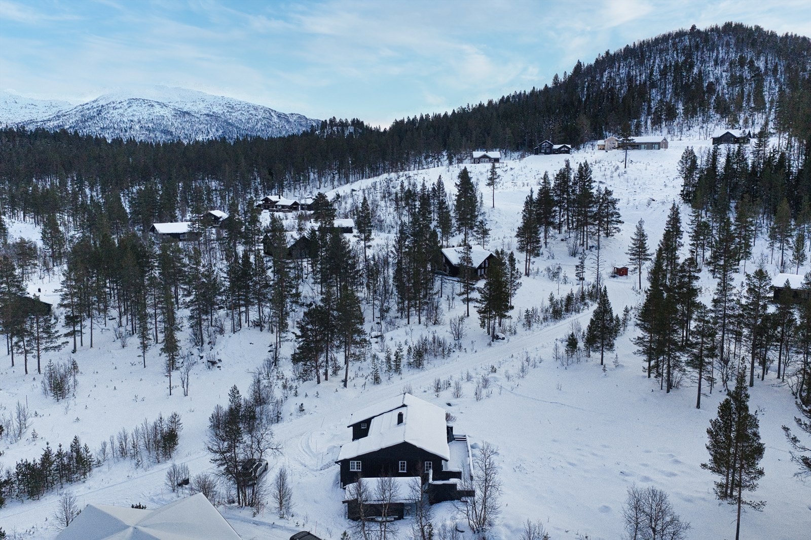 Hytten ligger fint til med utsikt mot fjellene i vest - badeplasser på sommeren kun få minuter unna. Galleribilde