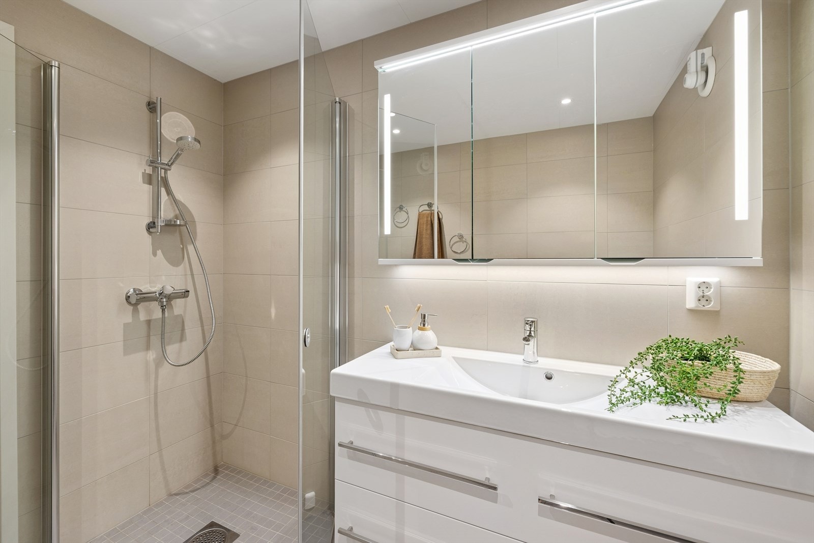 Pent bad med fliser på vegger og gulv med gulvvarme. Galleribilde