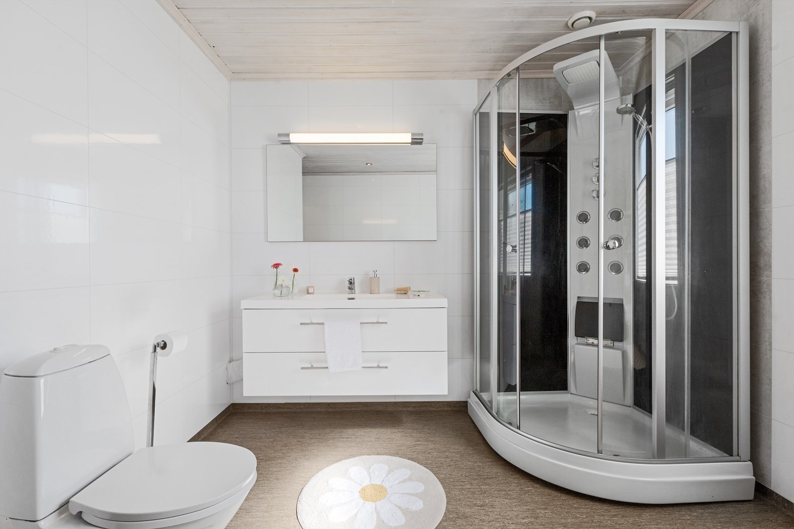 Badet er utstyrt med en bred servantinnredning og et dusjkabinett. Galleribilde