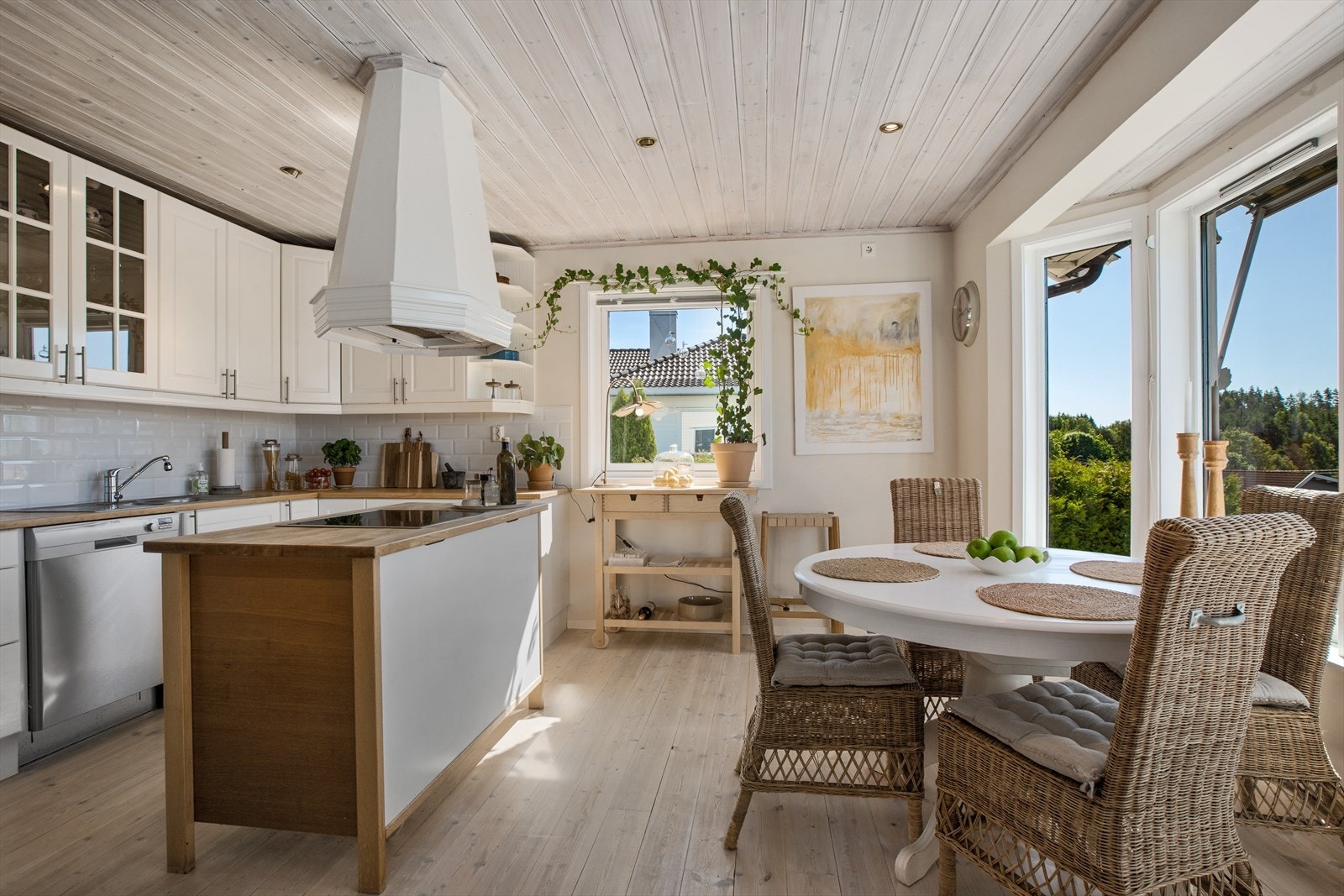 Stort og lyst kjøkken med en sentral kjøkkenøy og god plass til spisebord. Galleribilde