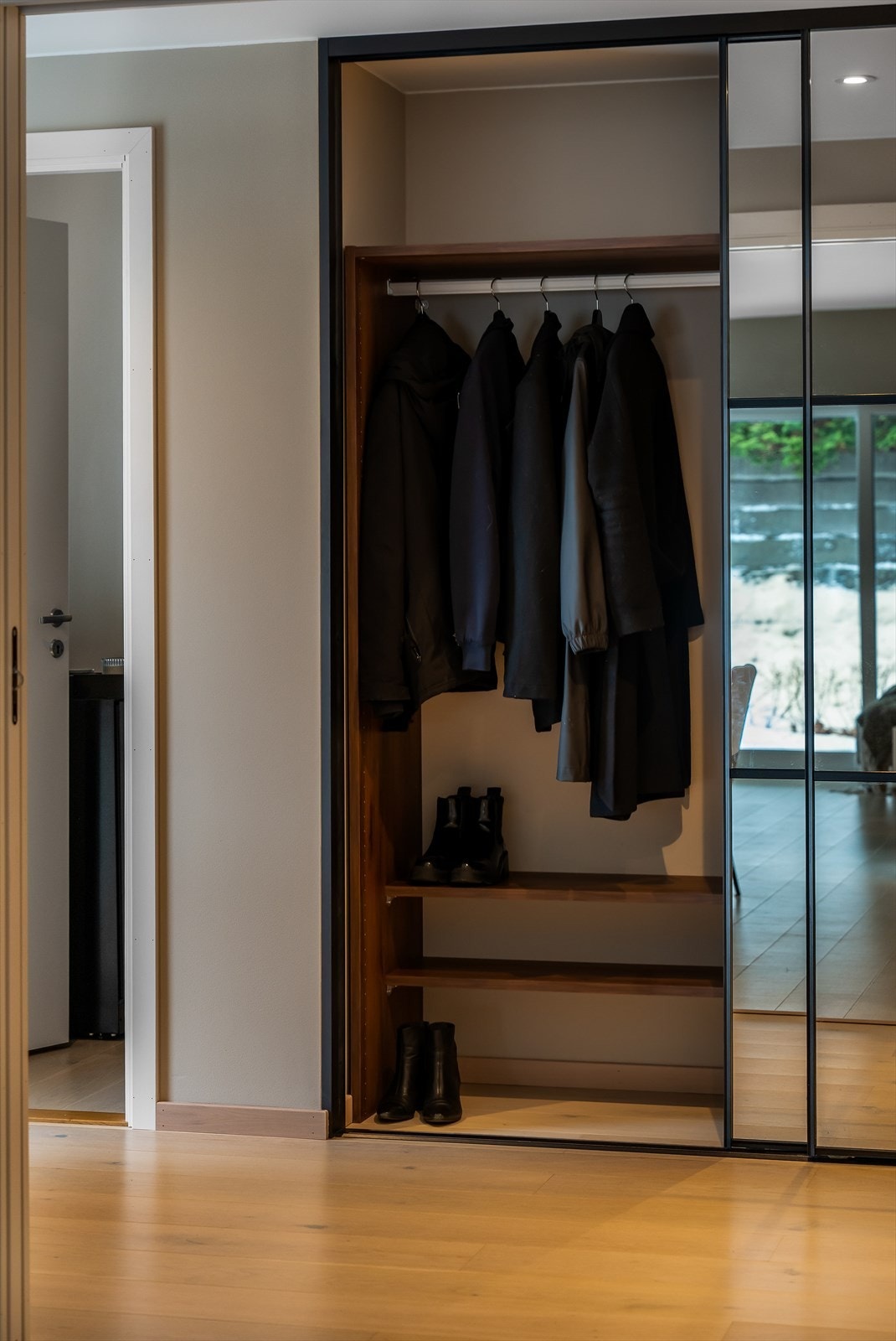 En stor skyvedørsgarderobe med speilfronter gir rikelig med lagringsplass for yttertøy. Galleribilde