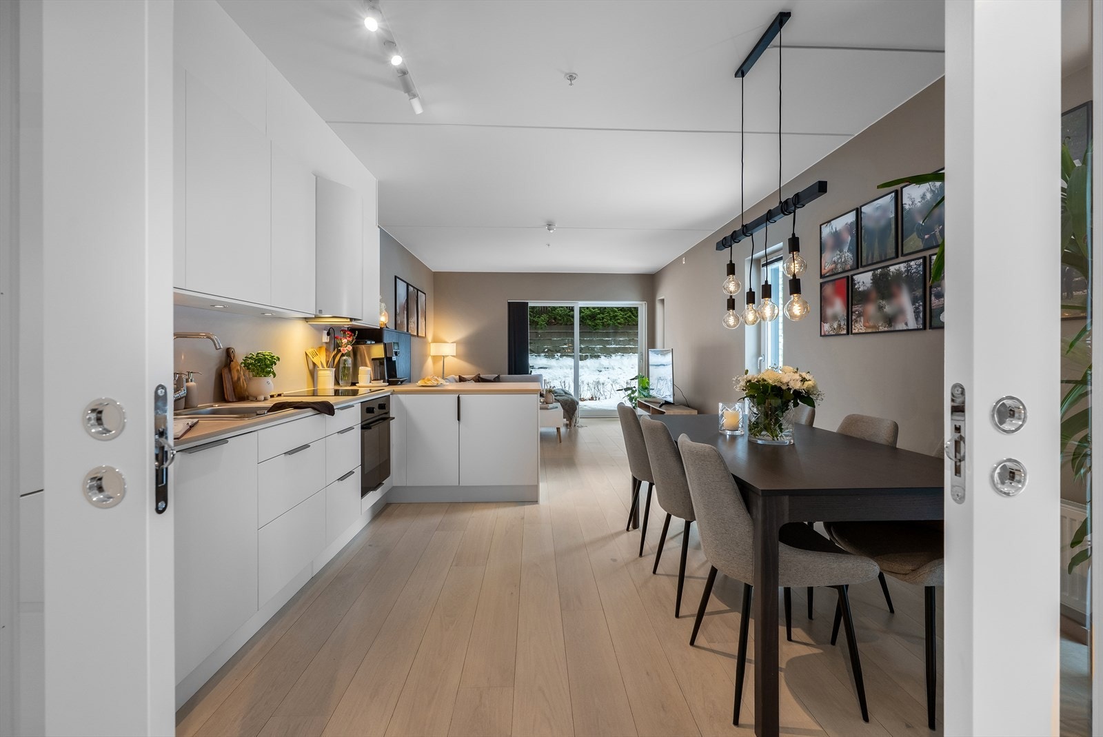 Moderne kjøkken med glatte fronter og en praktisk halvøy som avgrenser sonen. Galleribilde