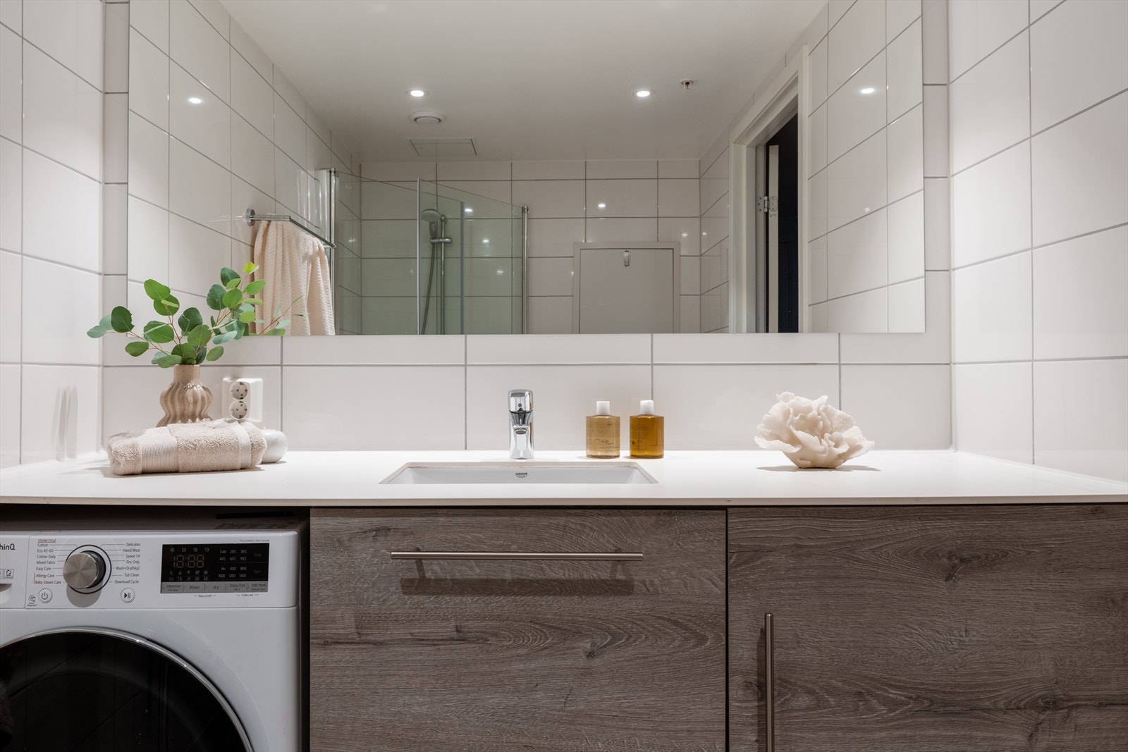 Innredning med underlimt servant og praktisk opplegg for vaskemaskin under benkeplaten. Galleribilde