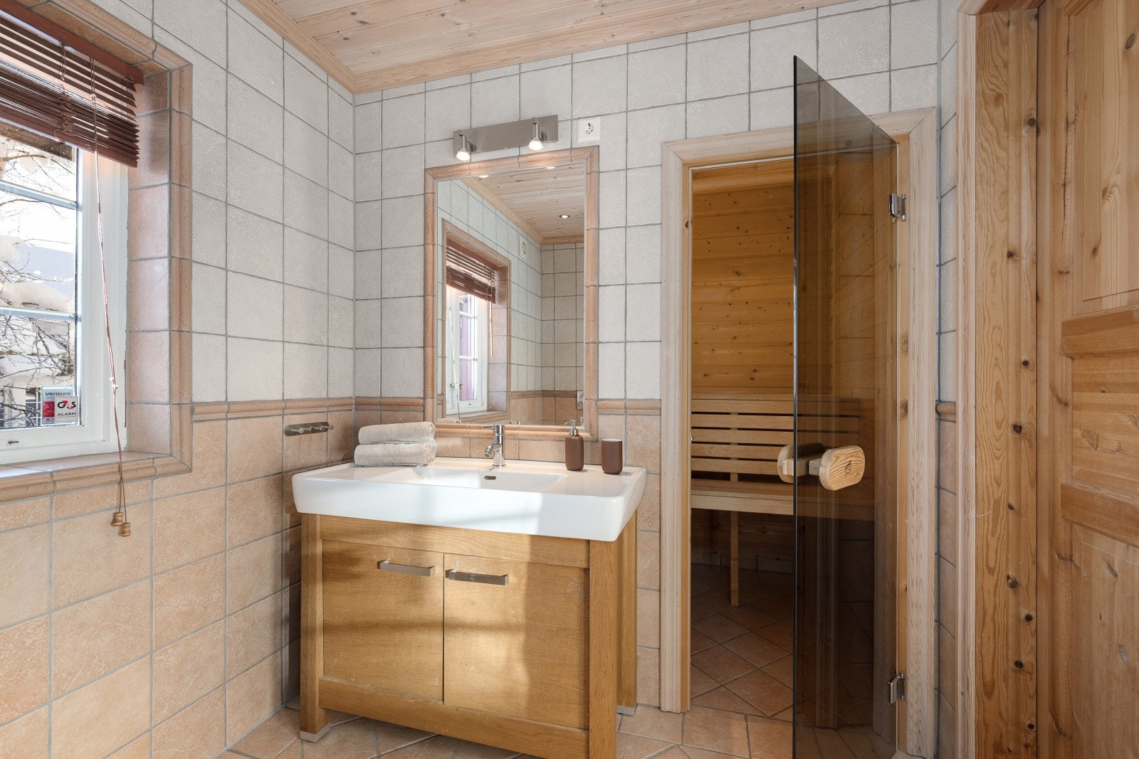 Badet er innredet med en servant med tilhørende underskap, speil med belysning, dusjvegger og et vegghengt toalett. Galleribilde