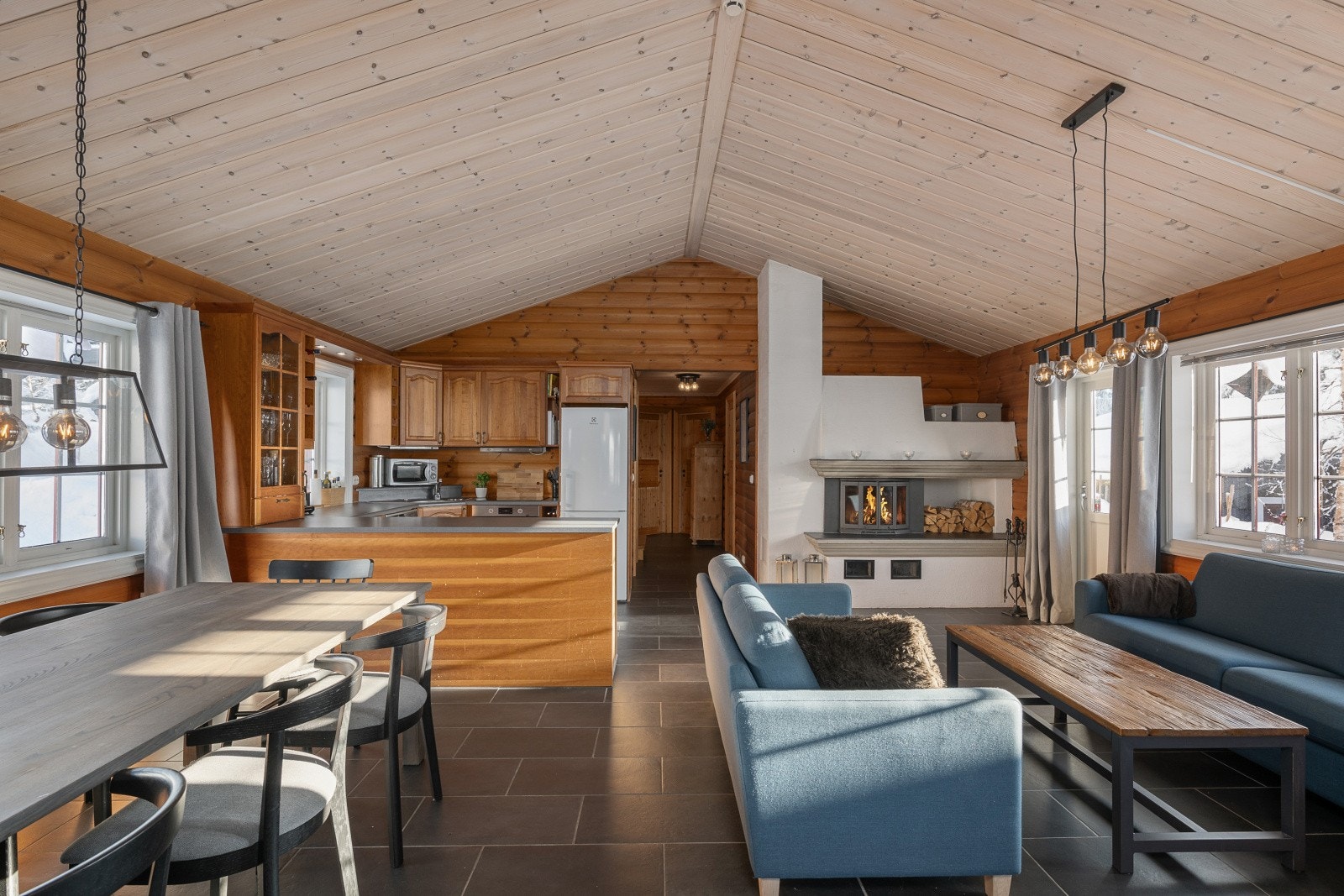 Stue og kjøkken utgjør et innbydende og luftig allrom som byr på rikelig med vindusflater og god takhøyde. Galleribilde