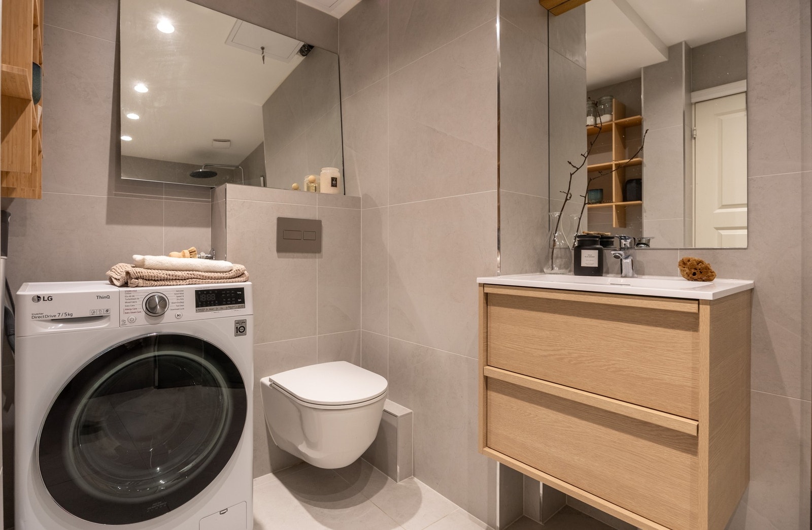 Vegghengt toalett med innebygget sisterne og avsatt plass til både vaskemaskin og tørketrommel. Galleribilde