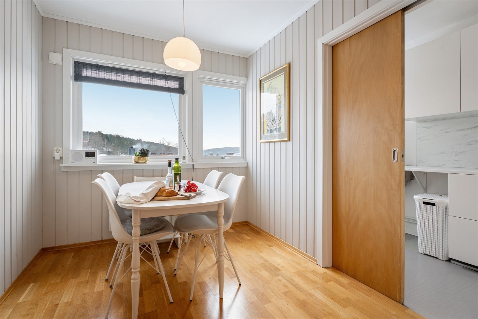 Leiligheten har et separat vaskerom, praktisk adskilt fra kjøkkenet med en plassbesparende skyvedør Galleribilde