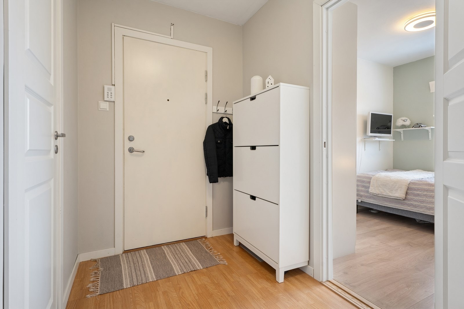 Gangen har god plass til å sette fra seg sko og henge fra seg yttertøy i et klassisk garderobeskap med glatte fronter Galleribilde