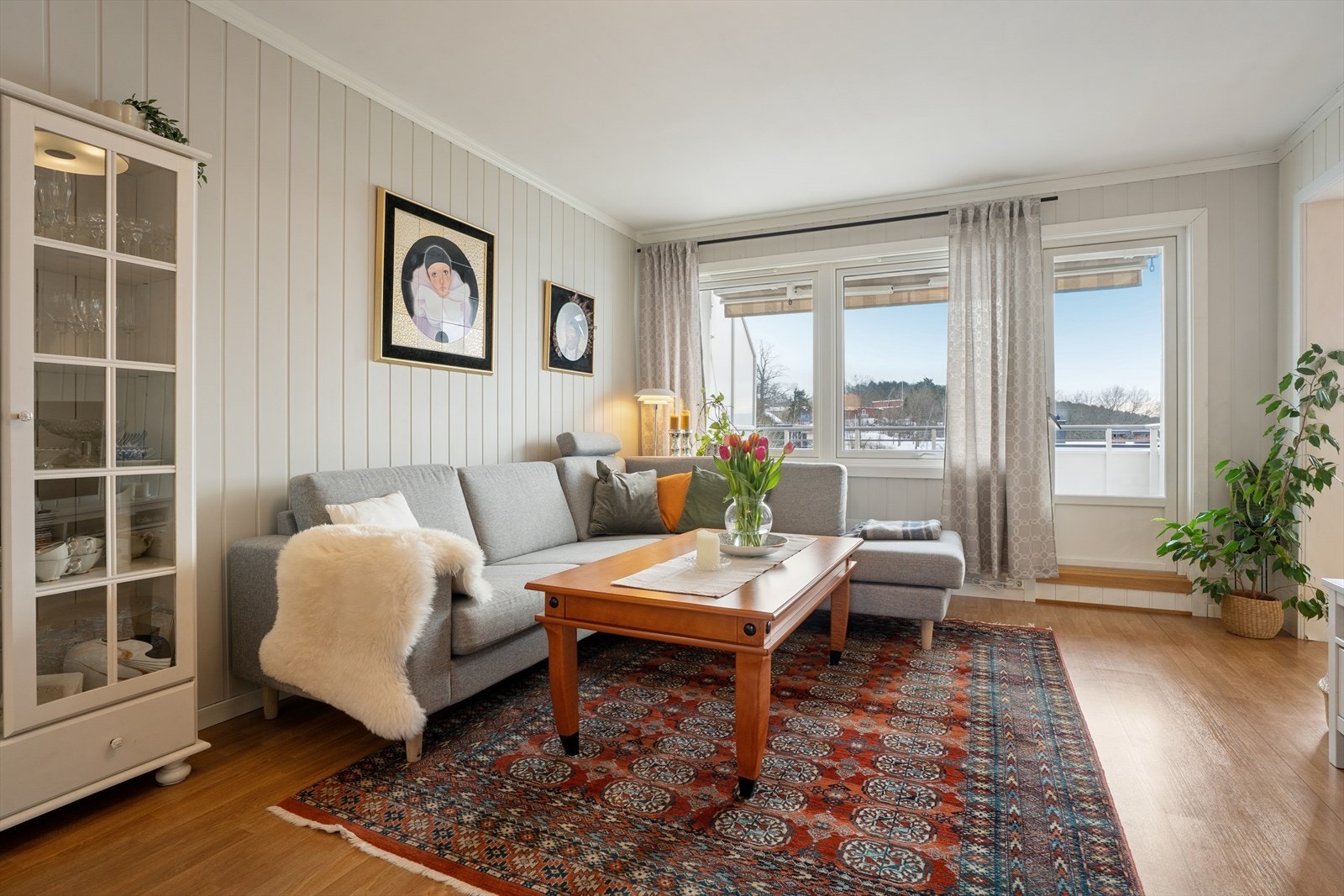 Stuen har lys smartpanel på veggene, og gulvet har klassisk parkett som bidrar til et moderne og innbydende uttrykk Galleribilde