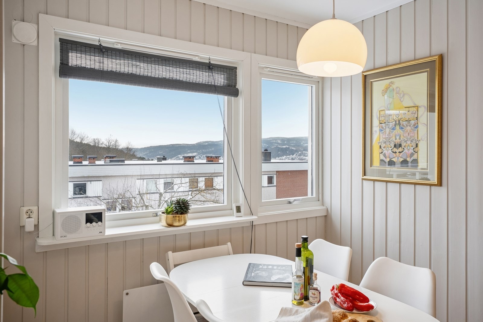 Fra spiseplassen er det nydelig utsikt mot nabolaget og store vinduer gir rikelig med naturlig dagslys Galleribilde