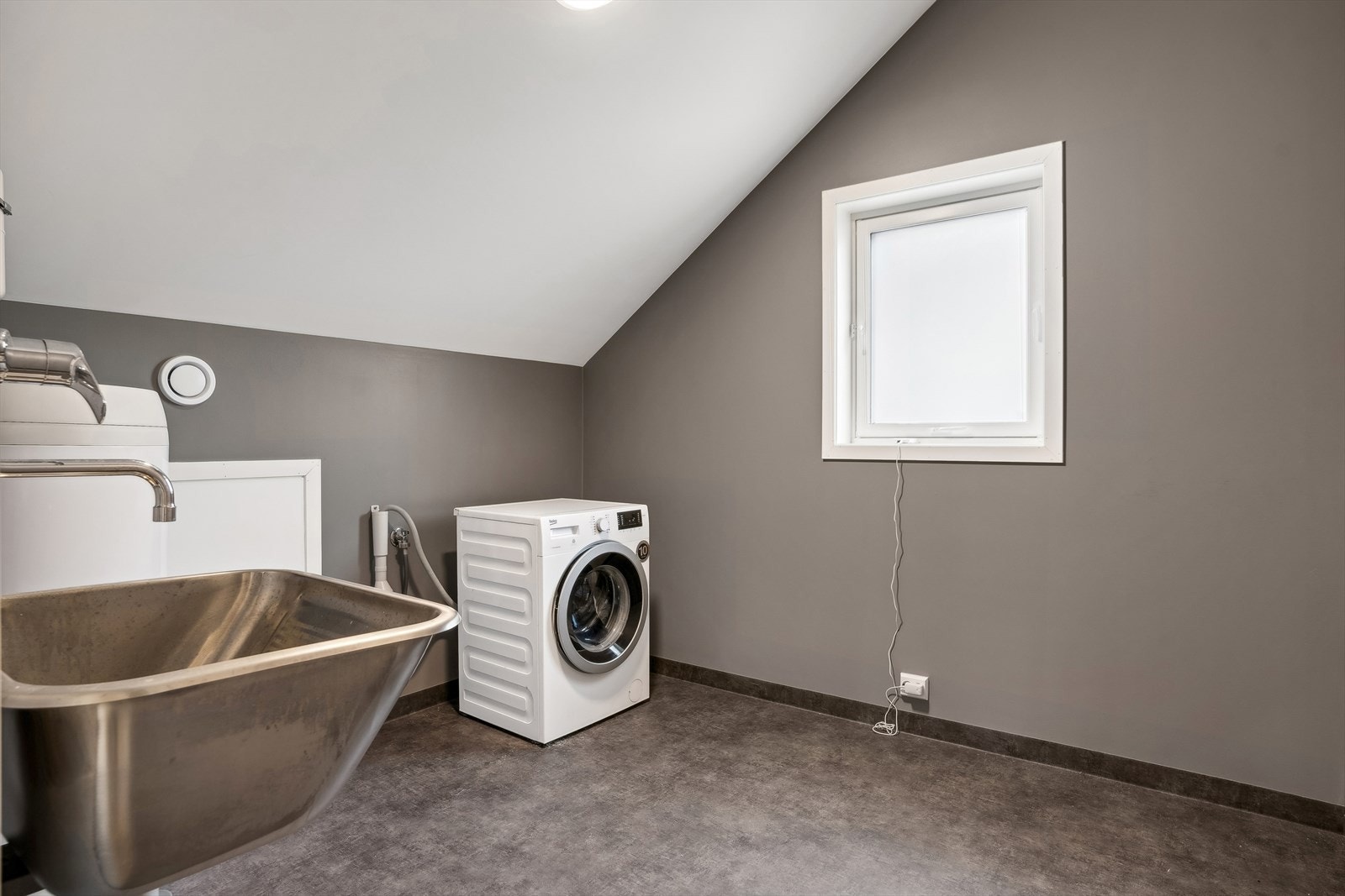 Praktisk med separat vaskerom. Her er det god plass til egnet innredning og er utstyrt med utslagsvask og opplegg til vaskemaskin. Galleribilde