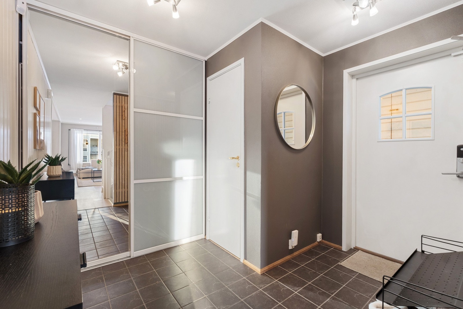 Flislagt entré med gulvvarme og praktisk skyvedørsgarderobe med speildør Galleribilde