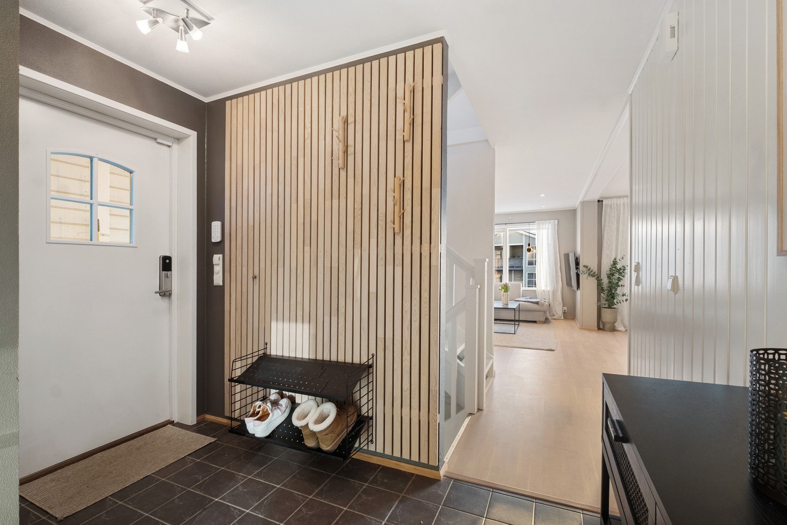 Flislagt entré med gulvvarme og praktisk skyvedørsgarderobe med speildør Galleribilde