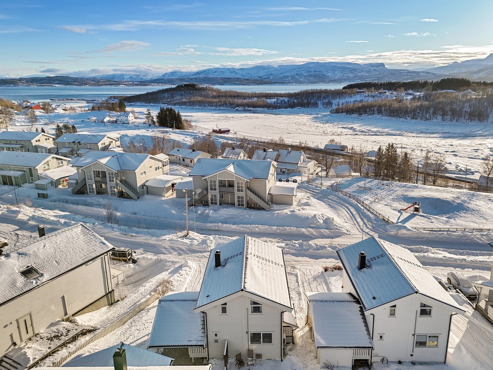 Tomten er lett skrånende og har en lettstelt hage med plen og steinlagt innkjørsel. På baksiden er det i tillegg etablert en koselig platting med spilevegg. Galleribilde
