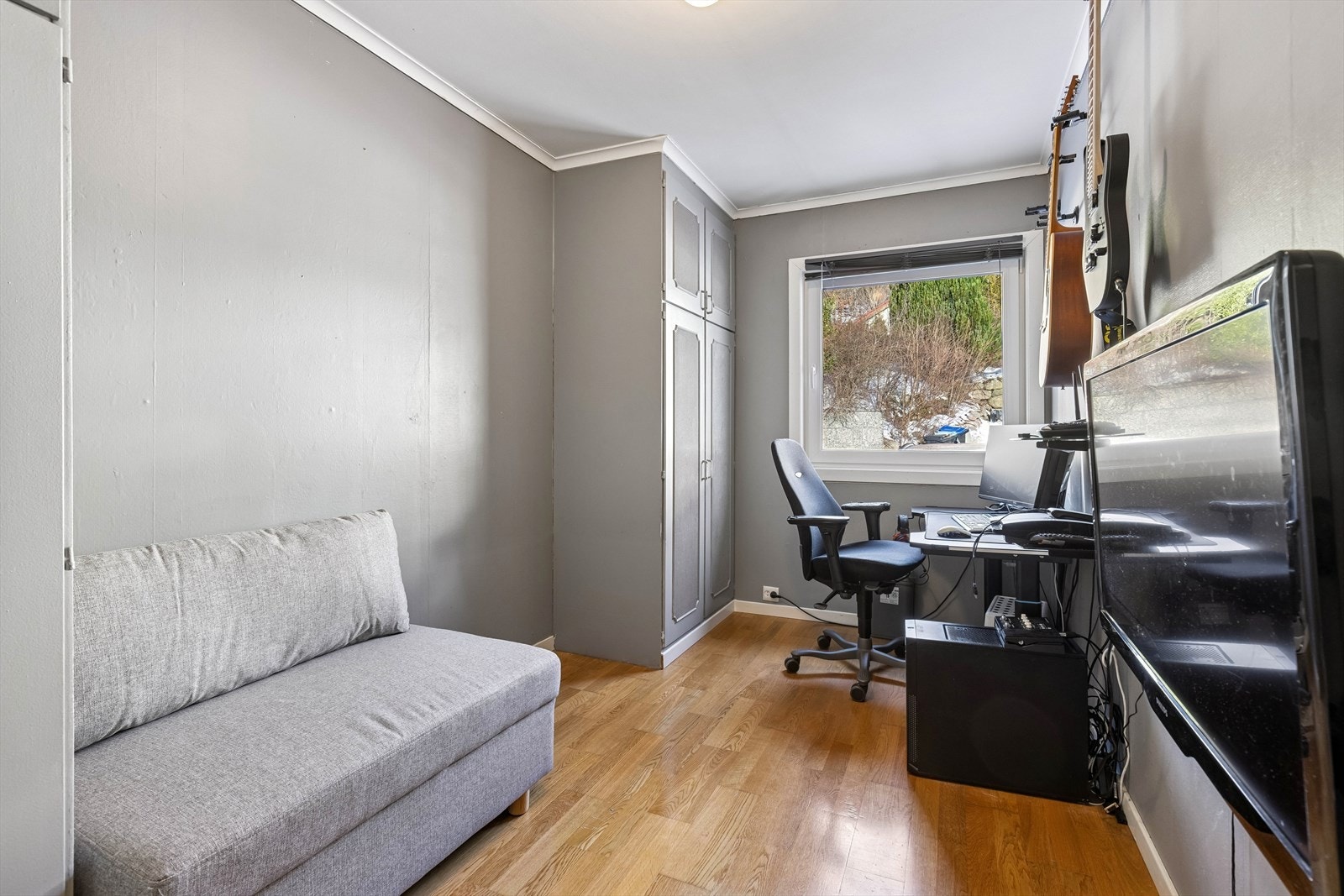 Soverom i hovedetasje med tapet på vegger, strietak og parkett gulv. Galleribilde