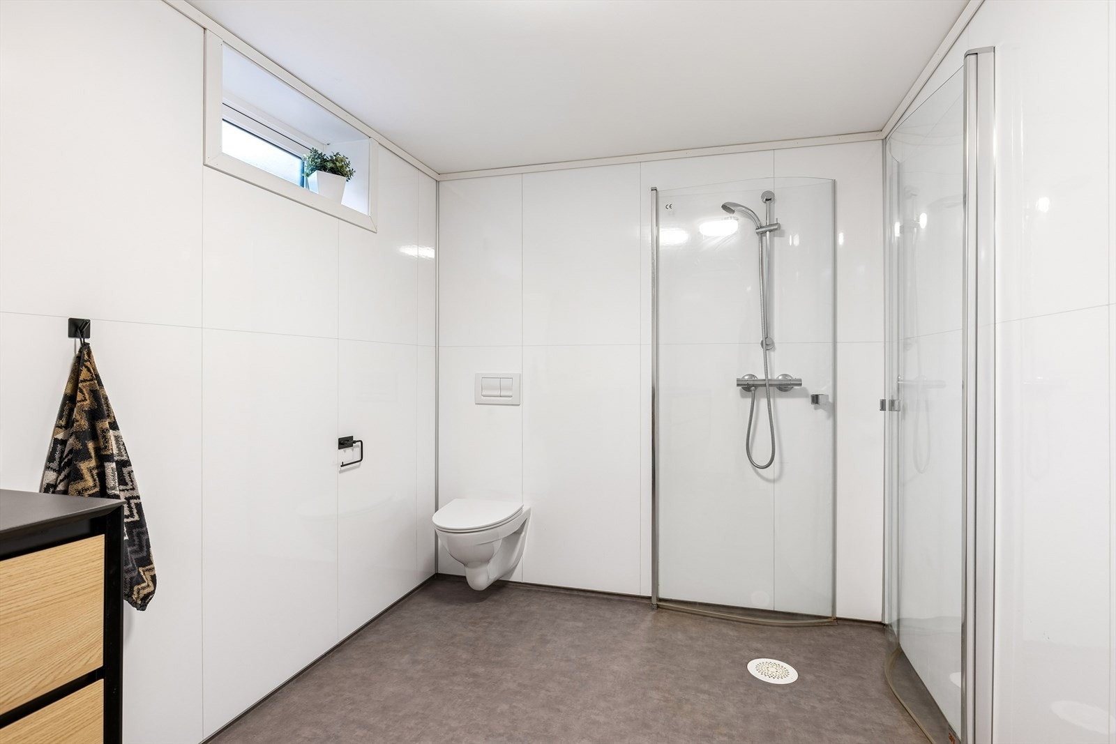 Bad i kjelleretasje med våtromsplater på vegger våtromsbelegg på gulv. Galleribilde